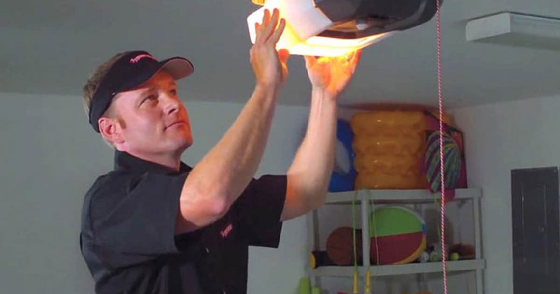 man inspecting garage door opener